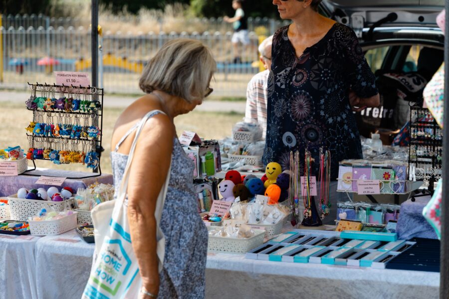 a grey haired woman browsing at a stall selling crafts on Allhallows field at Charter Day 2026