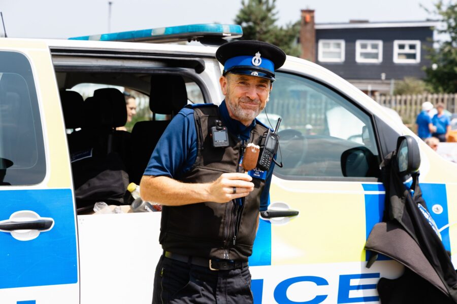 PCSO Darren England enjoying an ice cream beside a police van