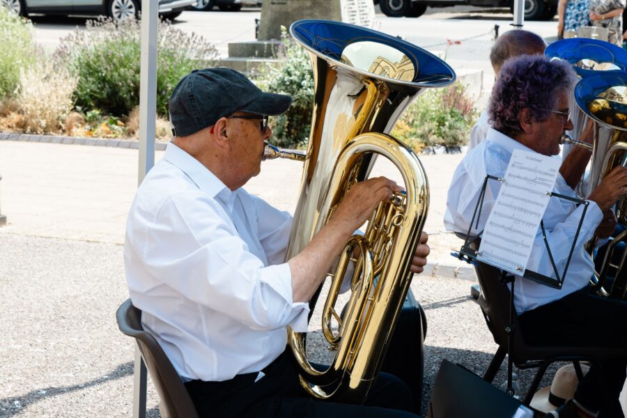 tuba player in Honiton Town Training Band playing in front of the war memorial at St Pauls Church