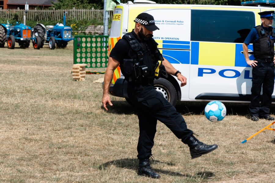 policeman kicking fooball with police van in background on Allhallows field at Charter Day 2026